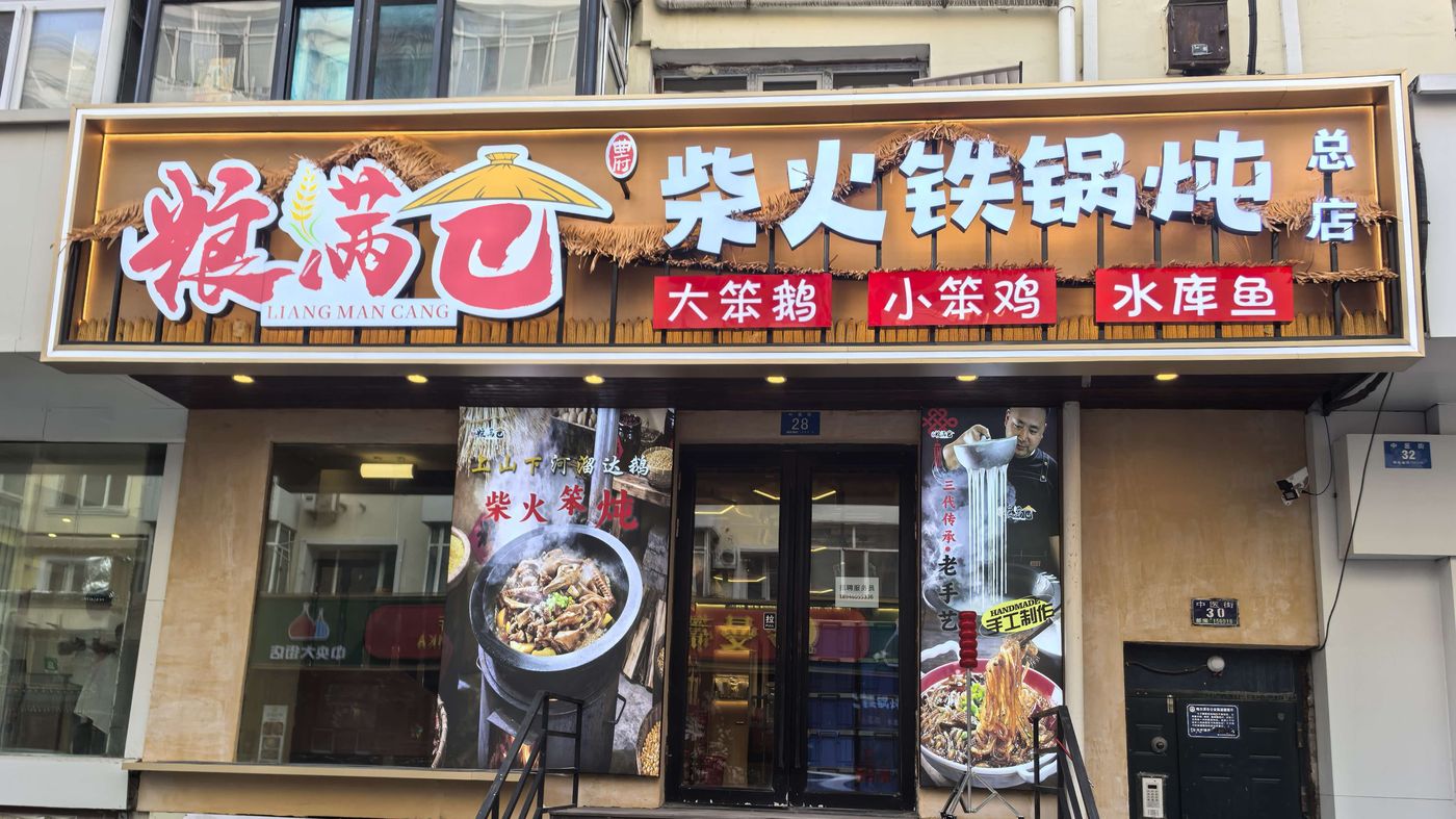 粮满仓柴火铁锅炖总店门头实拍,牌匾主打大笨鹅、小笨鸡、水库鱼